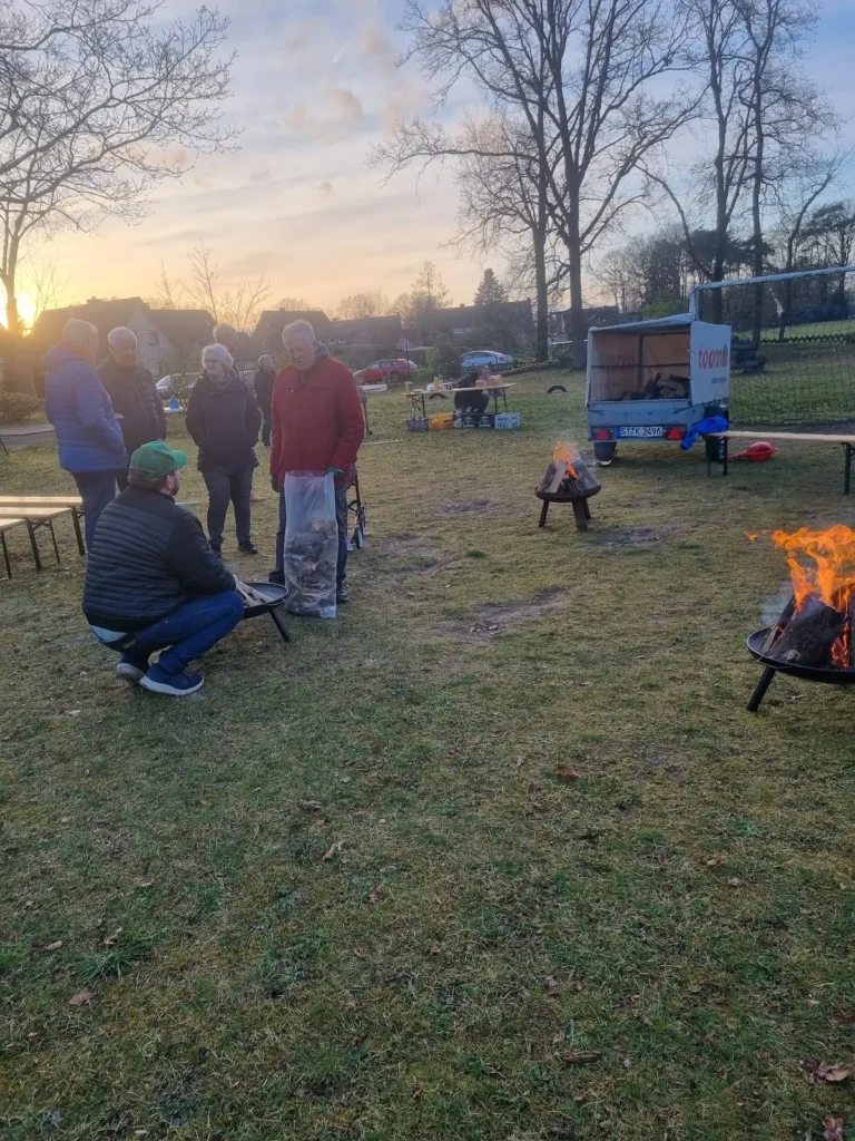 Vorbereitungen zum Osterfeuer mit ersten Besuchern.