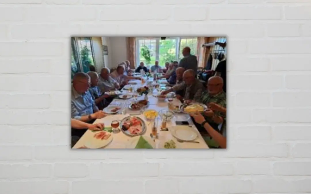 Ein langer Tisch mit einem Spargelbuffet und Männern, die es sich schmecken lassen