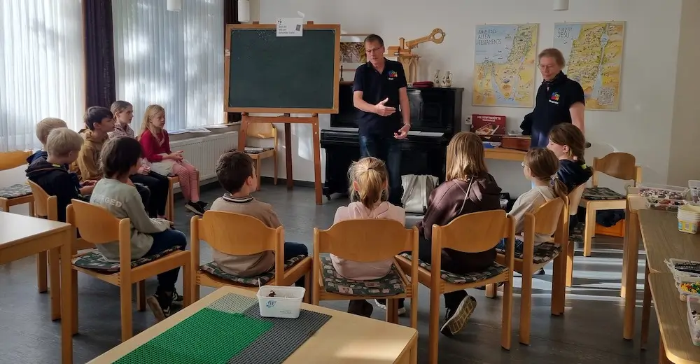 Kinder sitzen im Kreis um Knut Ahlborn, der ihnen die Geschichte vom verlorenen Sohn erzählt.