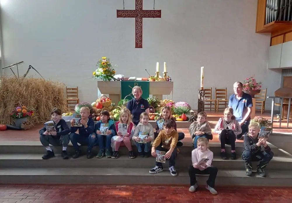 Die Gruppe der Kinder zum Projekt Lego trifft Bibel mit Knut und Margareta Ahlborn vor dem zu Erntedank geschmückten Altar der Johanneskirche Lengerich